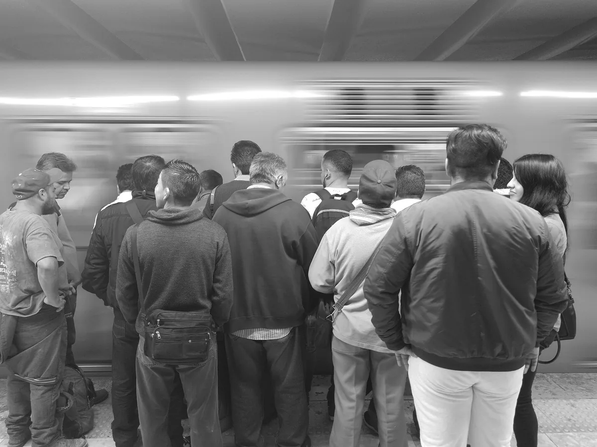 Commuters waiting on a Mexico City Metro platform as a train passes, the MX$5 ride that keeps a day's budget down